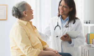 Doctor consulting with an elderly patient in a medical office.